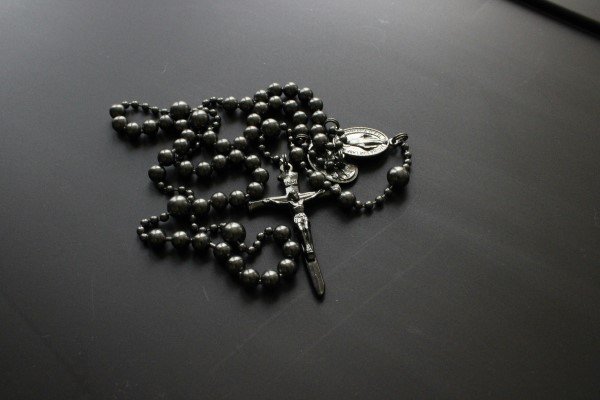 Santo Rosario con crucifijo y medalla que representa esta devocion, simbolizando la práctica de oración y devoción católica.